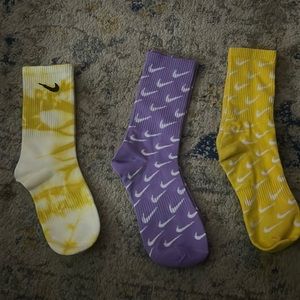 3pairs of Nike socks. Brand Nike. 2 yellows and 1 purple.